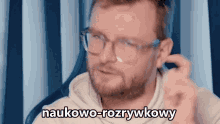 a man with glasses and a beard says " naukowo-rozrywkowy " in a foreign language