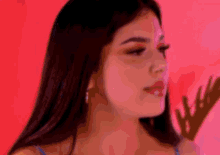 a close up of a woman 's face against a red background .