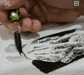 a close up of a person drawing with a gif icon