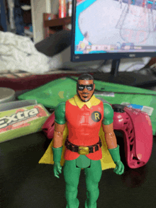 a robin action figure is standing in front of a box of extra chewing gum