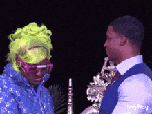 a man and a woman are standing next to each other and the man is wearing sunglasses