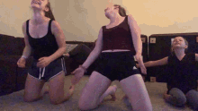 a group of young girls are kneeling on the floor dancing
