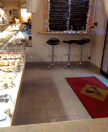 a bakery with a red mat and a sign that says ' welcome ' on it