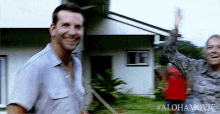 a man and woman are standing in front of a house .