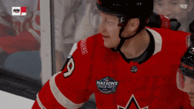 a hockey player wearing a red jersey that says nations face-off