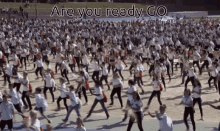 a large group of people are dancing in a field with the words are you ready go above them