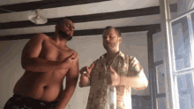 a shirtless man is standing next to another shirtless man