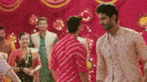 two men are dancing together in front of a crowd of people at a wedding reception .