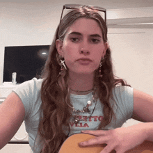 a woman wearing a t-shirt that says " bello villa " holds a guitar