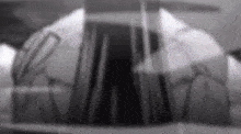 a black and white photo of a person standing in front of a glass wall .