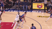 a basketball game is being played on a court sponsored by reviver gold