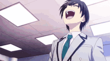 a man in a suit and tie is laughing with his mouth open in a room .