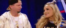 a man and a woman are standing next to each other on a stage and smiling .
