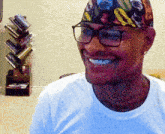 a man wearing glasses and a colorful headband smiles