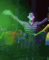 a man in a striped shirt is dancing with a woman in a yellow dress