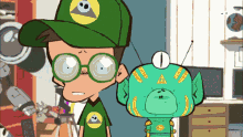 a boy wearing glasses and a green hat stands next to a green monster