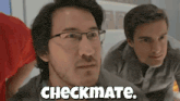 a man wearing glasses says checkmate in front of another man
