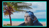 a man is sitting on a beach with a palm tree in the background and a sign that says #rendern gegen mobbing