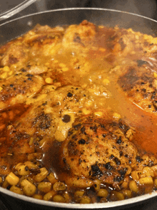 a pan filled with chicken and beans is being cooked