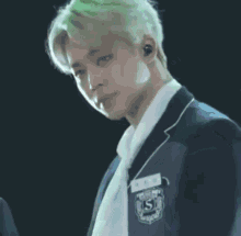 a man in a school uniform with the letter s on the badge