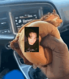 a person is holding a sandwich in their hand with a picture of a man on it .