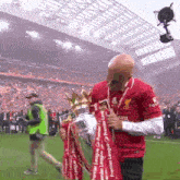 a man holding a trophy that says premier league