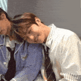 a man in a striped shirt is laying on another man 's shoulders