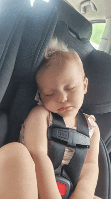 a baby is sleeping in a car seat with the word hug on the strap
