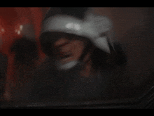 a man wearing a helmet screams with his mouth open