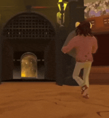 a woman in a pink sweater and white pants is running in front of a building