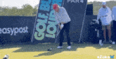 a man swings a golf club on a golf course in front of a banner that says easypost