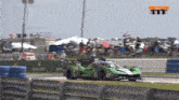a green race car with the number 63 on the side of it