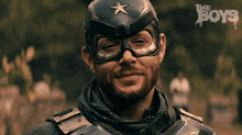 a man in a superhero costume is smiling and wearing a helmet with a star on it