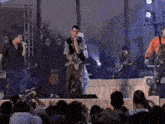 a man singing into a microphone while standing on stage