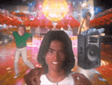 a group of people are dancing in front of a disco ball and a speaker