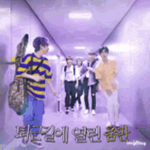 a group of people are walking down a hallway in a purple room .