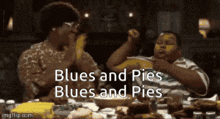 a man and a woman are sitting at a table with food and the words blues and pies written on the screen .
