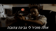 a man in a white shirt and tie holds a gun in front of a computer screen with a clock on the wall behind him