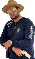 a man wearing a straw hat and sunglasses is wearing a shirt that says errea on the sleeve