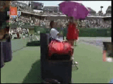 a blurry picture of a tennis court with a purple umbrella