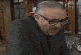 a man wearing glasses is eating a piece of pizza