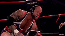 a wrestler with a canadian flag on his shirt is being punched by a referee .