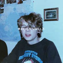 a person wearing a desert storm sweatshirt looks at the camera
