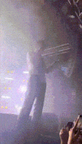a blurry picture of a person standing on a stage in front of a crowd