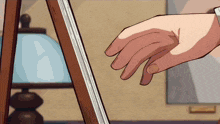 a person 's hand is touching a piece of paper on a wooden easel