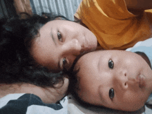a woman and a baby are laying on a bed together