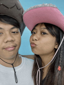 a man and a woman wearing cowboy hats are making funny faces