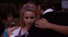 a woman with a purple headband is hugging a man