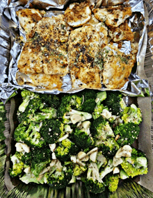 a plate of broccoli and chicken on tin foil on a table