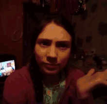 a woman in a purple jacket is making a face